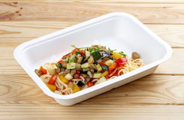 Sebzeli ortolana makarnası. Sağlıklı yiyecekler. Paket yemek. Ahşap bir arka planda.