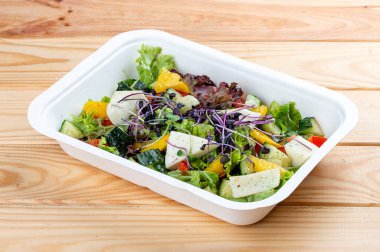 Camembert peynirli Fransız salatası. Sağlıklı yiyecekler. Paket yemek. Ahşap bir arka planda.