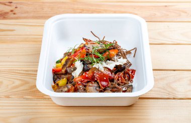 Sebzeli karabuğday eriştesi. Vejetaryen yemeği. Paket yemek. Ahşap bir arka planda.