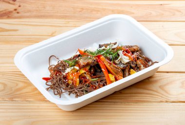 Sebzeli karabuğday eriştesi. Vejetaryen yemeği. Paket yemek. Ahşap bir arka planda.