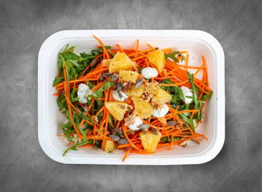 Carrot salad with orange. Healthly food. Takeaway food. Top view, on a gray background. clipart