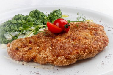 Soslu tavuk şnitzel, yanında brokoli ve peynirli börek..
