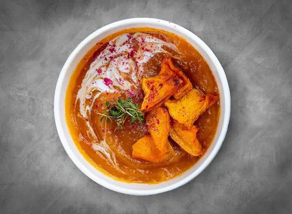 stock image Pumpkin cream soup. Healthy food. Takeaway food.  Top view, on a gray background.