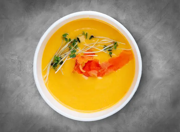 stock image Pumpkin cream soup. Healthy food. Takeaway food.  Top view, on a gray background.