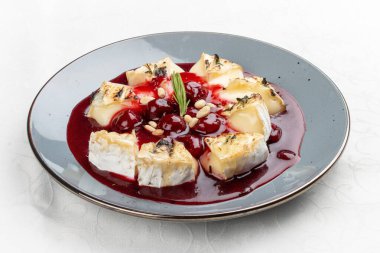 Yumuşak ve yapışkan olana kadar fırında pişirilmiş kremalı Camembert peyniri, canlı böğürtlen sosuyla servis edilir.. 