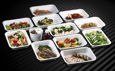 Taze ve lezzetli yemekler, sağlıklı ve elverişli bir yemek için çevreci konteynırlarda paketlenir..