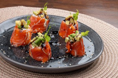 Krem peyniri ve olgun avokadoyla kaplanmış lezzetli füme somon dilimleri..