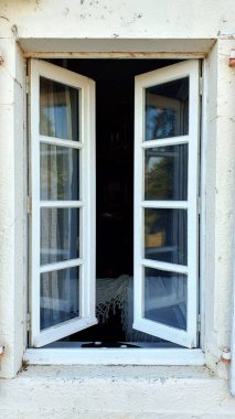 Zaman geçtikçe giyilen eski ahşap panjurlar. Pencereler evin dışını yansıtıyor ve içerisi de bir yatak gösteriyor..