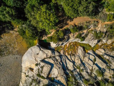 Doğal kristal berrak yeşil su havuzu ve yemyeşil bir ormanın ortasındaki kayaların arasında bir şelale..