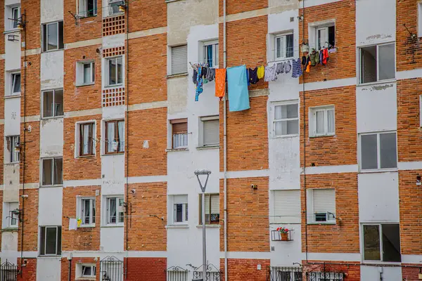 stock image The image showcases a multi-story residential building with a classic, rustic appearance characterized by alternating brick and white concrete walls. The structure is typical of an urban or suburban neighborhood, with multiple windows evenly spaced a