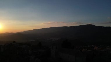 Günbatımında engebeli manzaralar ve dramatik manzaralarla çevrili tarihi bir köy olan Ciurana 'nın hava manzarası cazibesini ve antik mimarisini gözler önüne seriyor..