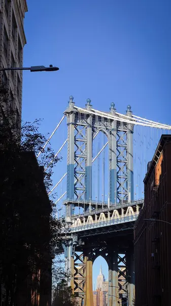 Manhattan Köprüsü 'nün açık mavi gökyüzünün altında, ikonik çelik tasarımı ve kentsel önemini gösteren detaylı bir görünüm..