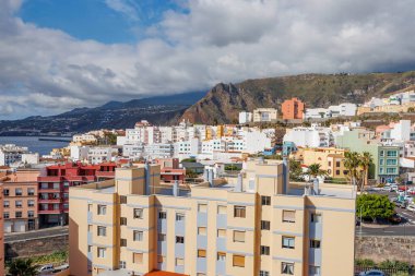 La Palma 'da canlı binaları, dağ zeminleri ve dramatik bulutlar altında Atlantik Okyanusu olan bir sahil kasabasının panoramik manzarası yükseldi..