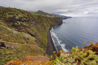Okyanus manzaralı engebeli bir kıyı şeridi boyunca dramatik jeolojik oluşumlar, volkanik katmanlar, erozyon dokuları ve doğal detayları gösteriyor..