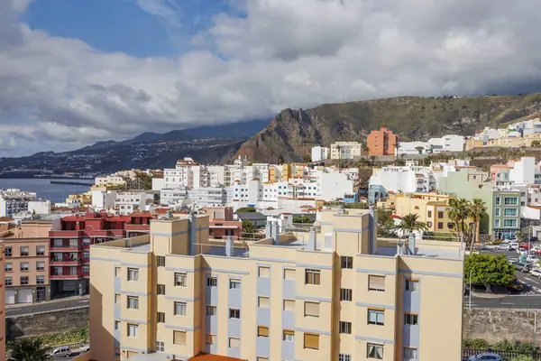 La Palma 'da canlı binaları, dağ zeminleri ve dramatik bulutlar altında Atlantik Okyanusu olan bir sahil kasabasının panoramik manzarası yükseldi..