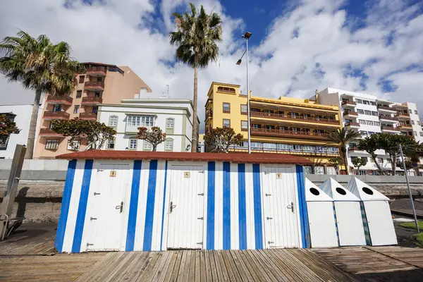 Arka planda canlı mimari ve palmiye ağaçları olan deniz kenarındaki kulübeler mevsim başlamadan önce yaz havasını çağrıştırıyor..