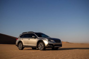 Gri Subaru, Namib çölünün kumlarında, parlak bir gökyüzünde. Walvis Körfezi, Namibya.