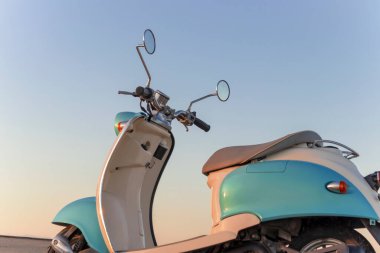 Namib Çölü 'nün altın kumda gün batımında geriye dönük mavi scooter.