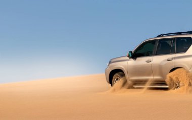 Namib çölünde kumda sıkışmış altın bir arabanın yakınında. Afrika