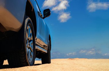 Namib çölünde kumda sıkışmış altın bir arabanın yakınında..