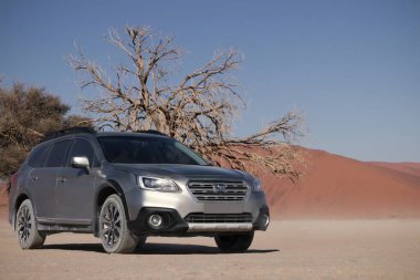 Gri Subaru, Namib çölünün kumlarında, parlak bir gökyüzüne karşı. Namibya.