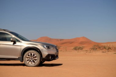 Gri Subaru, Namib çölünün kumlarında, parlak bir gökyüzünde.