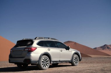 Gri Subaru, Namib çölünün kumlarında, parlak bir gökyüzüne karşı. Namibya.