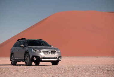Gri Subaru, Namib çölünün kumlarında, parlak bir gökyüzüne karşı. Namibya.