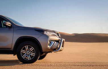 Namib Çölü 'nün kumlarında gri bir arabanın yakın çekimi.