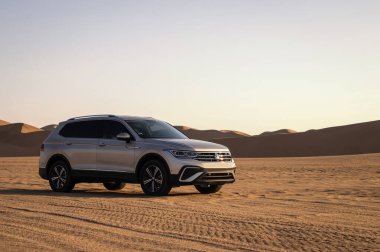 Volkswagen Tiguan Namib Çölü 'nün kumlarında parlak gökyüzüne karşı uzayda. Walvis Körfezi, Namibya.