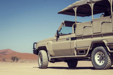 Güneşli bir günde çölün ortasında kahverengi bir off-road arabası.