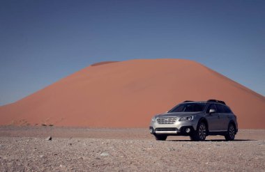 Gri Subaru Namib çölünün kumlarında parlak gökyüzüne karşı