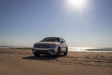 Volkswagen Tiguan, güneşli bir günde Atlantik Okyanusu 'nun kıyısındaki Namib Çölü' nün kumlarında.
