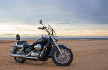 Çölde park etmiş off-road motosikleti dramatik bulutlu gökyüzü macerası seyahat, özgürlük ve aşırı doğa manzarası konsepti altında