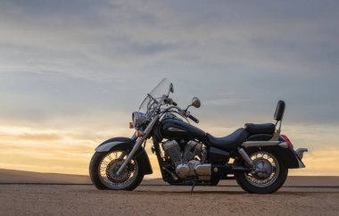 Çölde park etmiş off-road motosikleti dramatik bulutlu gökyüzü macerası seyahat, özgürlük ve aşırı doğa manzarası konsepti altında