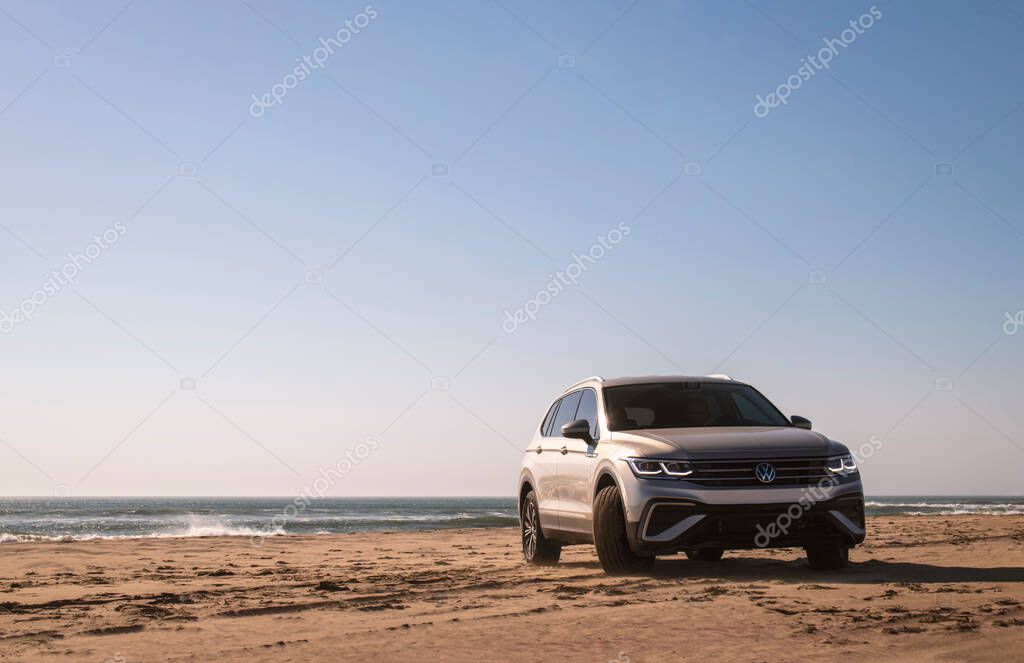 Volkswagen Tiguan allspace in the sands of the Namib Desert on the shores of the Atlantic Ocean on a sunny day.