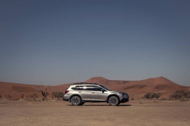 Gri Subaru Namib çölünün kumlarında parlak gökyüzüne karşı
