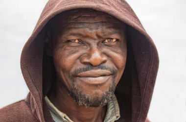 Derin kırışıklıkları ve anlamlı gözleri olan yaşlı bir Afrikalı adamın portresi. İnsan gücünü, bilgeliğini ve zamansızlığını yansıtan doğal ve duygusal bir görüntü.