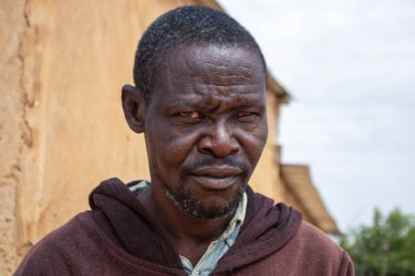 Derin kırışıklıkları ve anlamlı gözleri olan yaşlı bir Afrikalı adamın portresi. İnsan gücünü, bilgeliğini ve zamansızlığını yansıtan doğal ve duygusal bir görüntü.