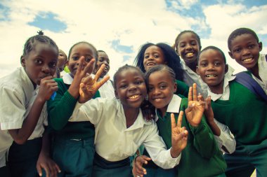 Okul üniformalı mutlu siyah Afrikalı çocuklar gülümsüyor ve tatilin tadını çıkarıyor. Gençliğin, eğitimin, çeşitliliğin ve toplum ruhunun olumlu bir görüntüsü.