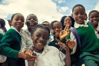 Okul üniformalı mutlu siyah Afrikalı çocuklar gülümsüyor ve tatilin tadını çıkarıyor. Gençliğin, eğitimin, çeşitliliğin ve toplum ruhunun olumlu bir görüntüsü.