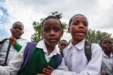 Okul üniformalı mutlu siyah Afrikalı çocuklar gülümsüyor ve tatilin tadını çıkarıyor. Gençliğin, eğitimin, çeşitliliğin ve toplum ruhunun olumlu bir görüntüsü.