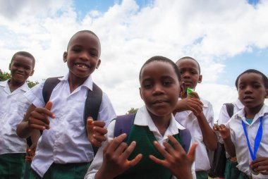 Okul üniformalı mutlu siyah Afrikalı çocuklar gülümsüyor ve tatilin tadını çıkarıyor. Gençliğin, eğitimin, çeşitliliğin ve toplum ruhunun olumlu bir görüntüsü.