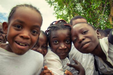Okul üniformalı mutlu siyah Afrikalı çocuklar gülümsüyor ve tatilin tadını çıkarıyor. Gençliğin, eğitimin, çeşitliliğin ve toplum ruhunun olumlu bir görüntüsü.