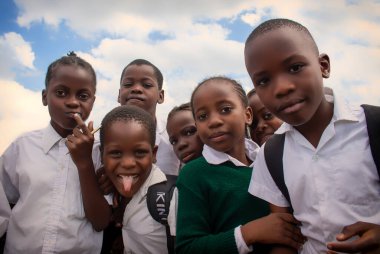 Okul üniformalı mutlu siyah Afrikalı çocuklar gülümsüyor ve tatilin tadını çıkarıyor. Gençliğin, eğitimin, çeşitliliğin ve toplum ruhunun olumlu bir görüntüsü.