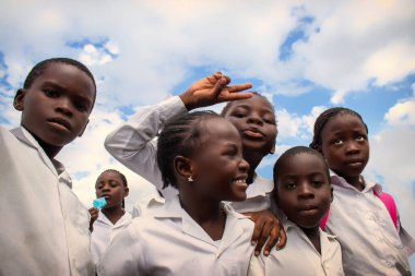 Okul üniformalı mutlu siyah Afrikalı çocuklar gülümsüyor ve tatilin tadını çıkarıyor. Gençliğin, eğitimin, çeşitliliğin ve toplum ruhunun olumlu bir görüntüsü.