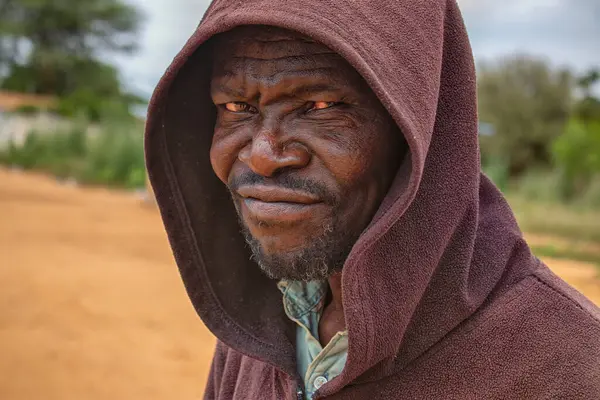 Derin kırışıklıkları ve anlamlı gözleri olan yaşlı bir Afrikalı adamın portresi. İnsan gücünü, bilgeliğini ve zamansızlığını yansıtan doğal ve duygusal bir görüntü.