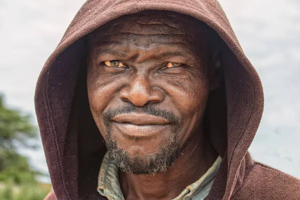 Derin kırışıklıkları ve anlamlı gözleri olan yaşlı bir Afrikalı adamın portresi. İnsan gücünü, bilgeliğini ve zamansızlığını yansıtan doğal ve duygusal bir görüntü.