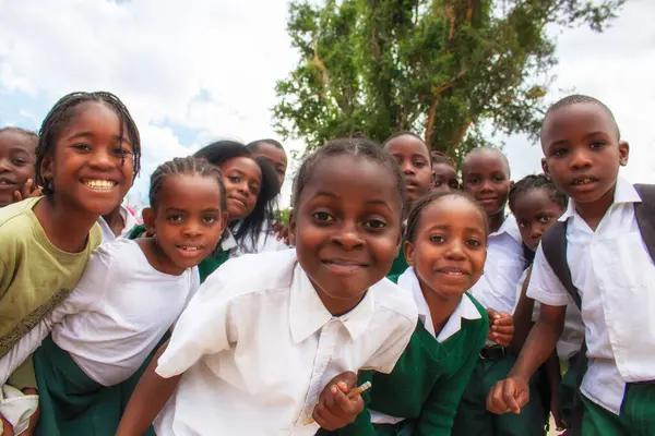 Okul üniformalı mutlu siyah Afrikalı çocuklar gülümsüyor ve tatilin tadını çıkarıyor. Gençliğin, eğitimin, çeşitliliğin ve toplum ruhunun olumlu bir görüntüsü.