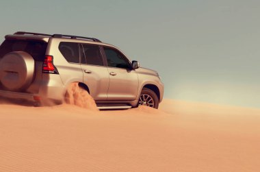 Namib Çölü 'nün uzak kumda sıkışmış bir SUV, Namibya' daki zorlu sürüş koşullarının ve çöl keşiflerinin gerçekliğini vurgulayan editoryal yakalama. 